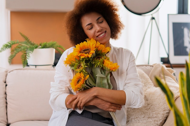 Gratis foto medium shot vrouw met prachtige zonnebloemen