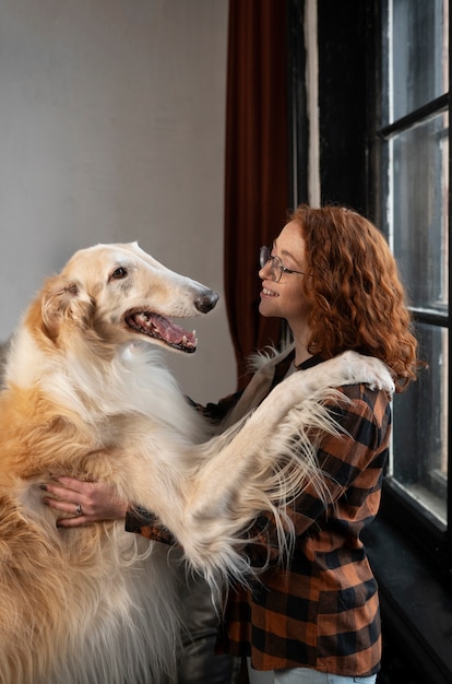 Gratis foto medium shot vrouw met schattige windhondhond