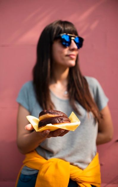 Medium shot vrouw met zonnebril en donuts