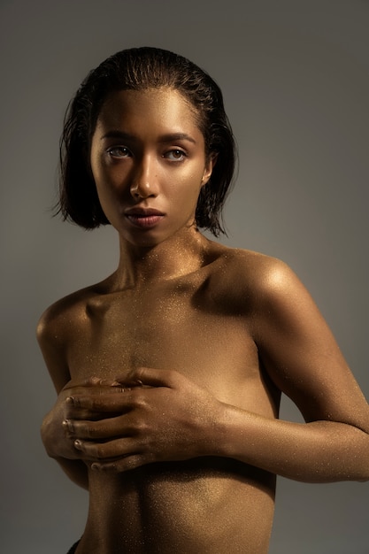 Medium shot vrouw poseren met gouden bodypainting
