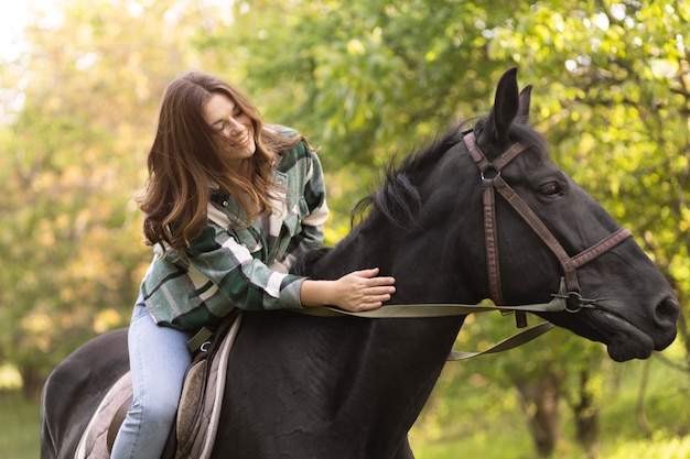 Medium shot vrouw rijdt paard