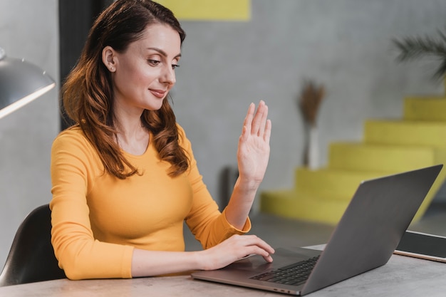 Medium shot vrouw zwaaien naar laptop