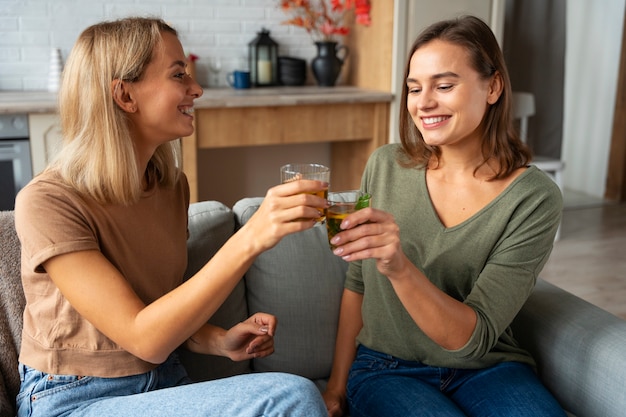 Gratis foto medium shot vrouwen met kombucha chatten