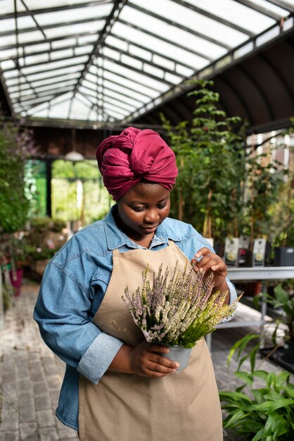 Medium shot zwarte vrouw die een bloemenzaak runt