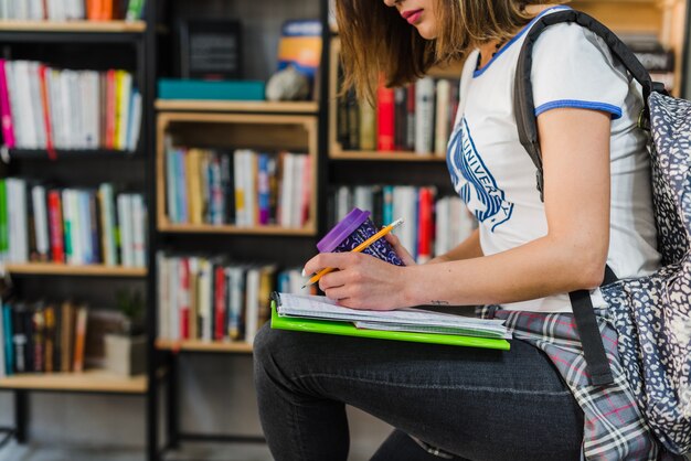 Meisje bedrijf notitieboekje op knie schrijven