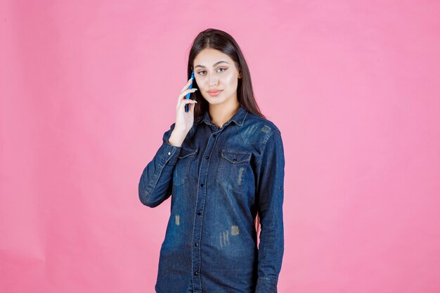 Meisje bedrijf praten met haar blauwe smartphone