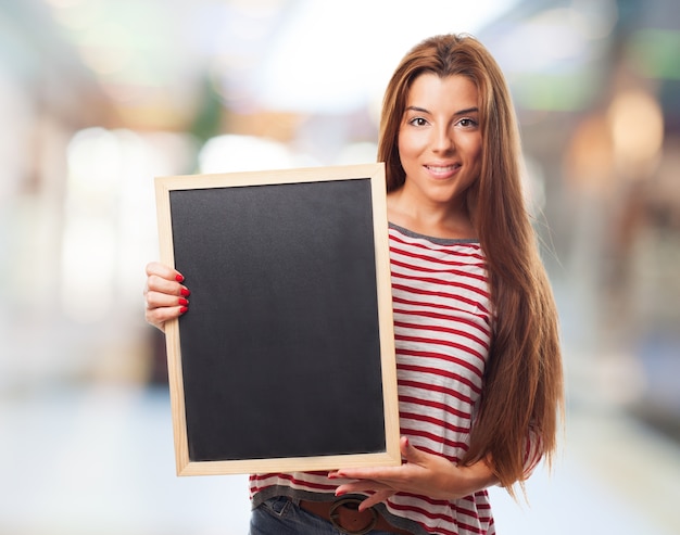 Gratis foto meisje bedrijf schoolbord in houten frame