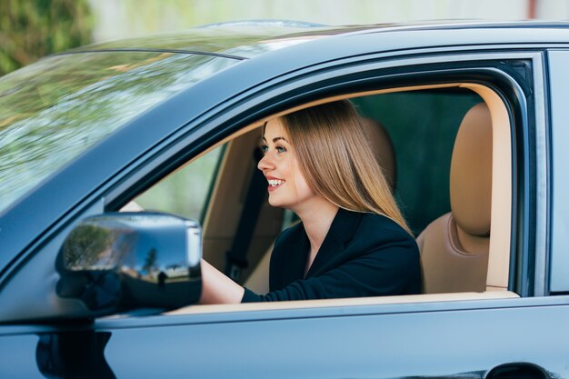 Meisje bestuurt een auto met verschillende gebaren en emoties