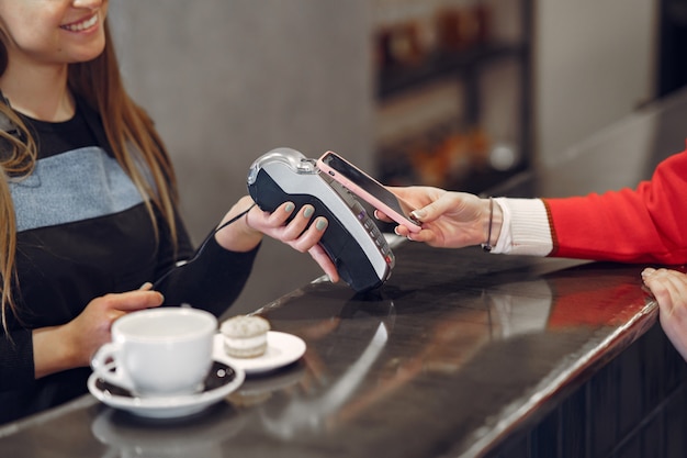 Meisje betaalt voor haar latte met een smartphone door contactloze PAY PASS-technologie
