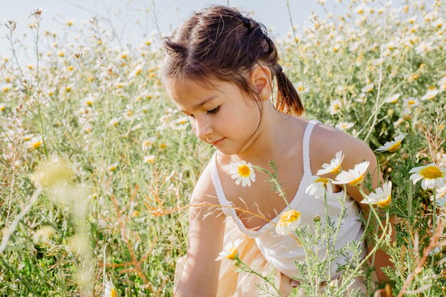 Meisje bloemen plukken in veld