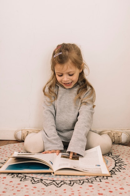 Meisje dat beelden in boek bekijkt