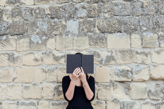 Meisje dat een boek in de straat leest