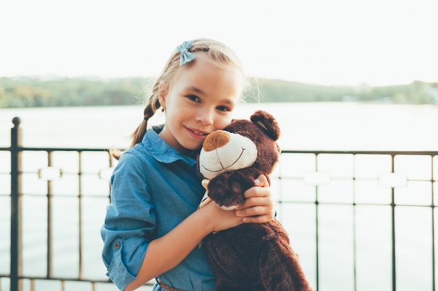 Meisje dat een leuke teddybeer omhelst