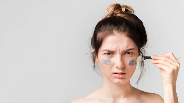 Meisje dat haar cosmetisch product toepast
