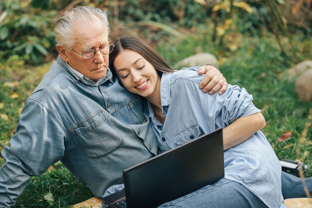 Meisje dat haar grootvader onderwijst hoe een laptop te gebruiken