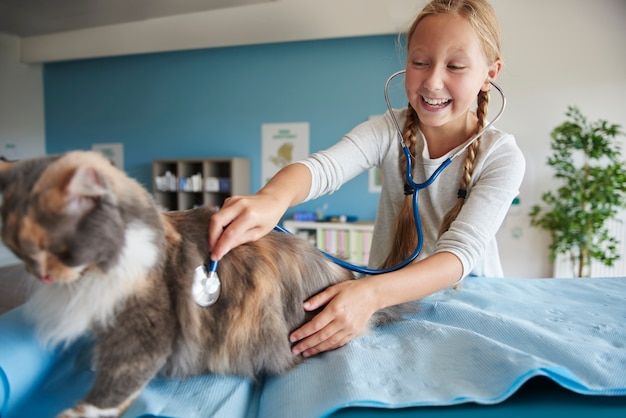 Gratis foto meisje dat haar kat probeert te onderzoeken