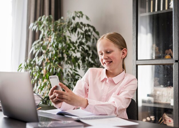 Meisje dat haar telefoon in klasse controleert