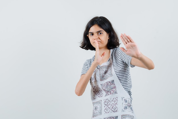 Meisje dat handen opheft om zich in t-shirt te verdedigen