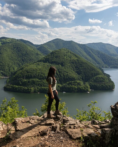 Meisje dat het landschap van het bergmeer overziet in Tarnita, Transsylvanië, Roemenië