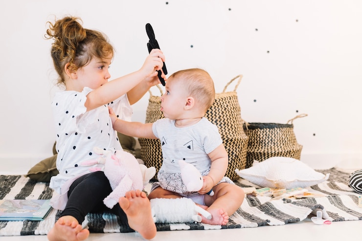 Gratis Foto meisje dat hoofdband op baby zet