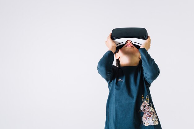 Meisje dat in VR-hoofdtelefoon omhoog kijkt