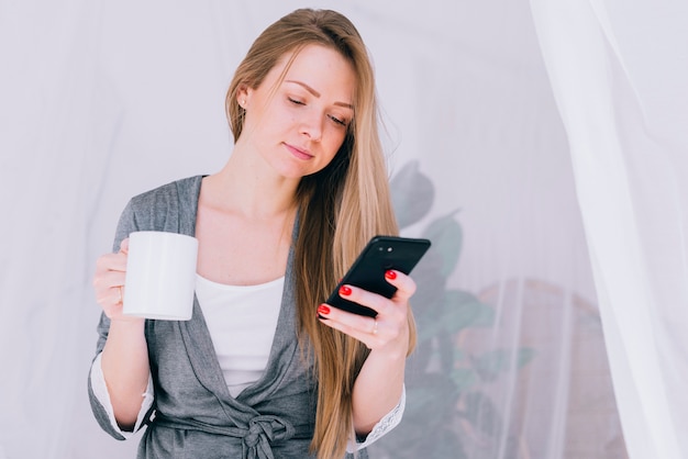 Meisje dat koffie met de mobiele telefoon heeft