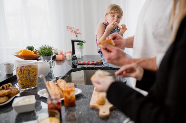 Meisje dat ouders bekijkt die sandwiches voorbereiden