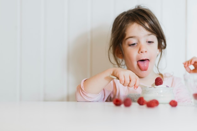 Meisje dat smakelijke framboos eet