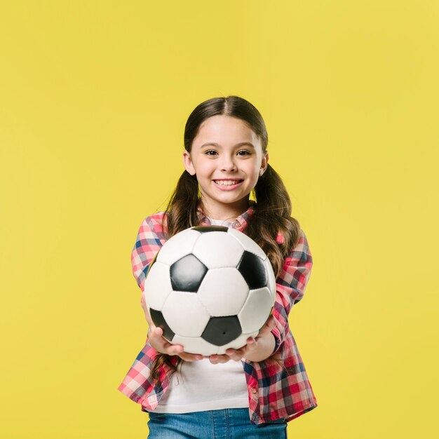 Meisje dat voetbal in studio toont