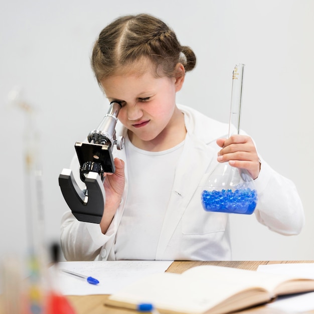Meisje dat wetenschap met microscoop leert te doen