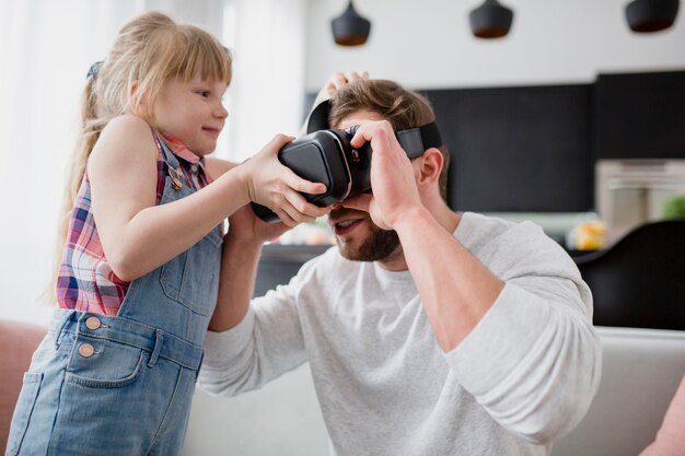 Meisje dichtbij vader in VR-hoofdtelefoon