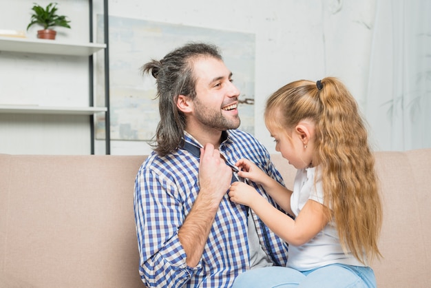 Gratis foto meisje dichtknopen haar vaders shirt