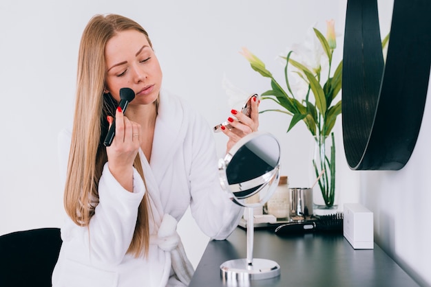 Meisje doet haar make-up in de badkamer