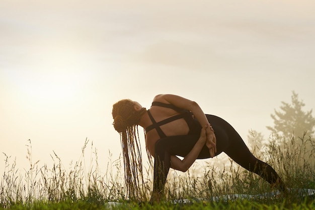 Meisje doet yoga pose in de natuur