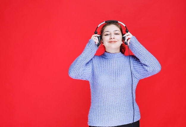 Meisje draagt haar koptelefoon om naar de muziek te luisteren.