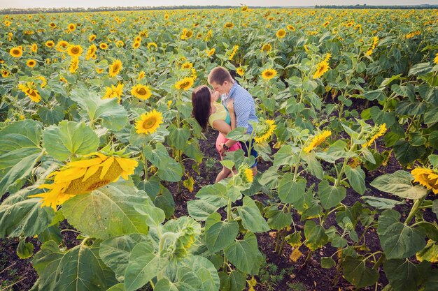 Meisje en man in een veld met zonnebloemen