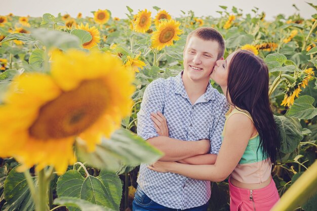 Meisje en man in een veld met zonnebloemen