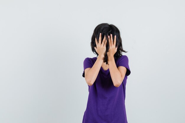Meisje hand in hand op gezicht in t-shirt en bang op zoek.