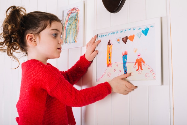 Meisje hangende omlijsting op muur