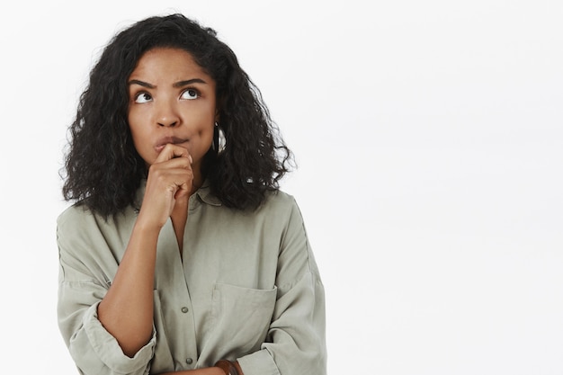 Meisje heeft make-up nodig, denkend, gefocust in een doordachte houding