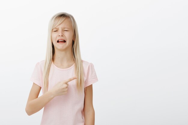 Meisje huilen en klagen naar rechts wijzend