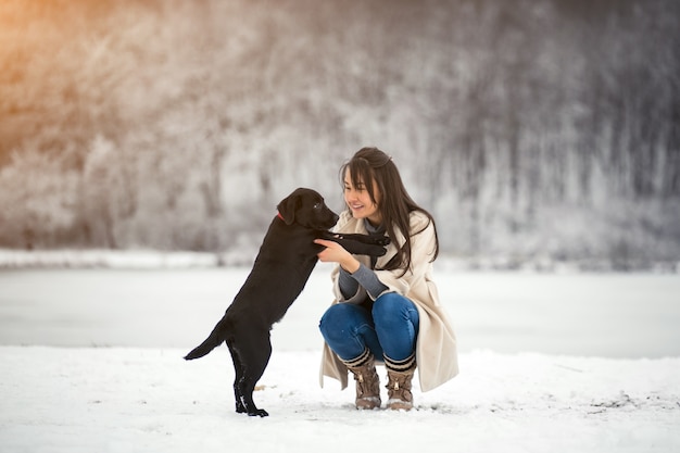 Meisje in de winter het spelen met hond