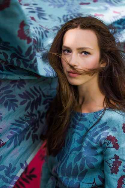 meisje in een linnen jurk. met een krans van bloemen op haar hoofd.