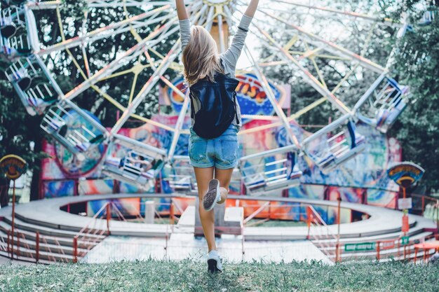 Meisje in een pretpark op de achtergrond van een draaimolen