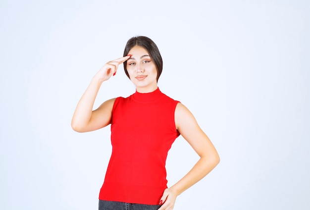 Meisje in een rood shirt dat iemand begroet of uitnodigt.