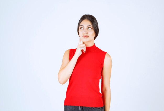 Meisje in een rood shirt dat positieve en verleidelijke poses geeft.