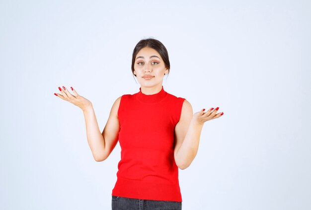 Meisje in een rood shirt dat positieve en verleidelijke poses geeft.