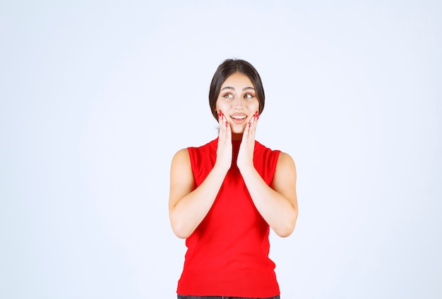 Meisje in een rood shirt dat positieve en verleidelijke poses geeft.