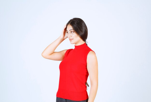 Meisje in een rood shirt dat positieve en verleidelijke poses geeft.