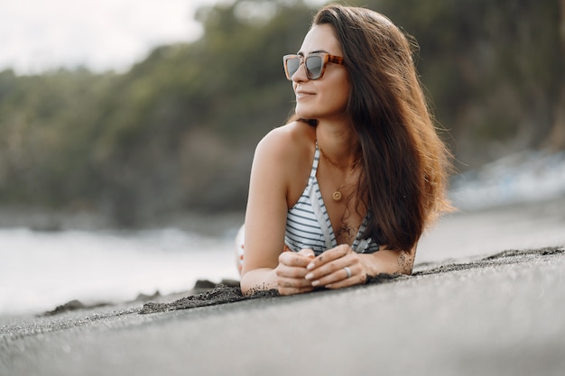 Meisje in een stijlvol badpak hebben een rust na strand